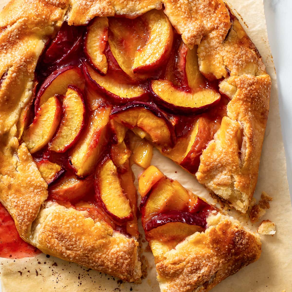 This gluten free peach galette combines a buttery, flaky pie crust with a small mountain of thickly sliced, juicy peaches that get beautifully tender (but not mushy!) in the oven. It’s incredibly easy to make and it’s absolutely divine served still warm, with a generous scoop of vanilla ice cream.