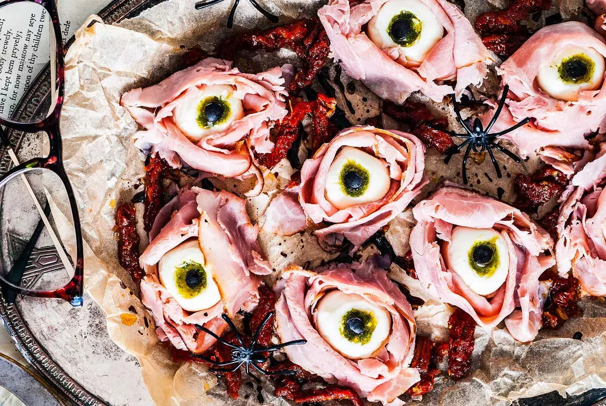 A gory-looking grown-up treat, these antipasto eyeballs are made with ham, mozzarella, olives, and pesto for a deliciously eerie bite.