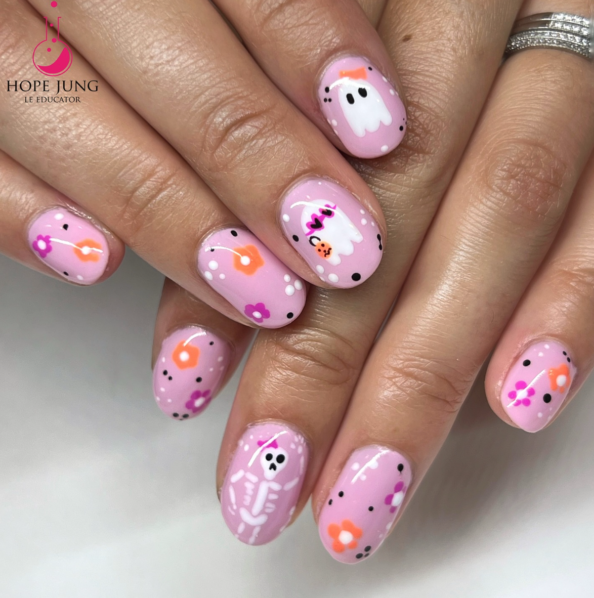 Girly Ghost Glam – Pink nails with flowers, ghosts, skeletons, and candy details for a playful pastel Halloween look.