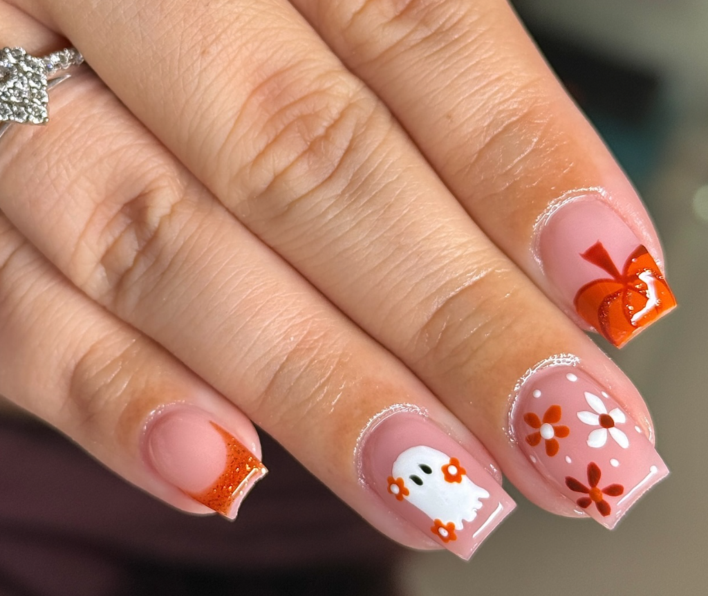 Retro Ghost Vibes – Orange French tips meet daisies and a friendly ghost for a 70s-inspired Halloween mani.
