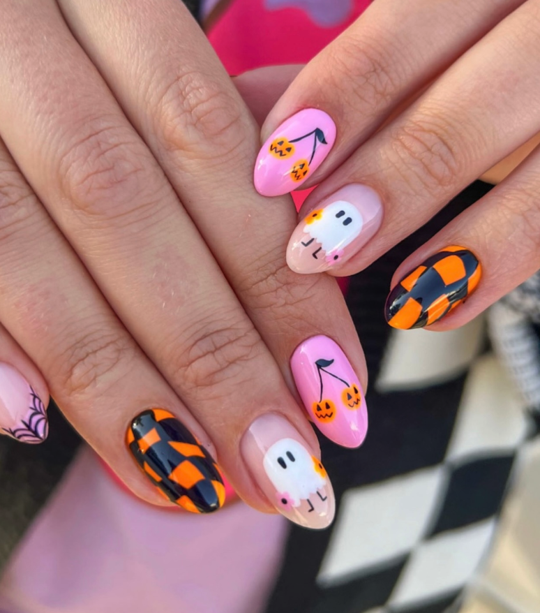 Playful Pastel Halloween – Pink nails get a spooky-cute twist with ghosts, pumpkin cherries, and bold checkerboard.