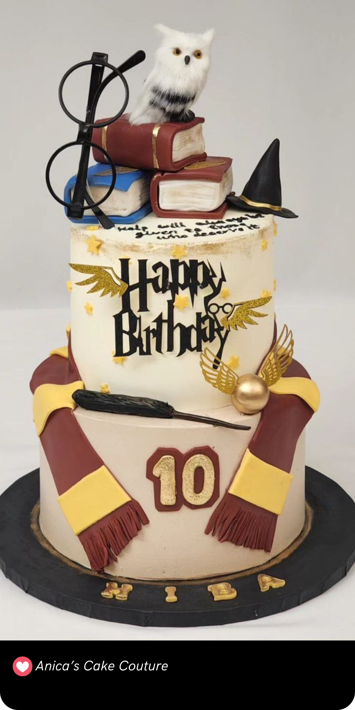 This charming Harry Potter-themed cake is bursting with magical details! The cake features Hedwig perched atop a stack of spellbooks, accompanied by Harry’s iconic glasses and wand. With a Gryffindor scarf draped around the bottom tier and golden snitches adding a whimsical touch, it’s a delightful tribute for any young wizard’s birthday celebration!