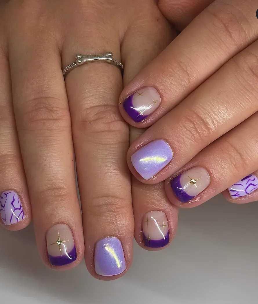 Short nails, big energy — these tiny galaxies shine with purple gradients, mini constellations, and subtle crackle lines for texture.