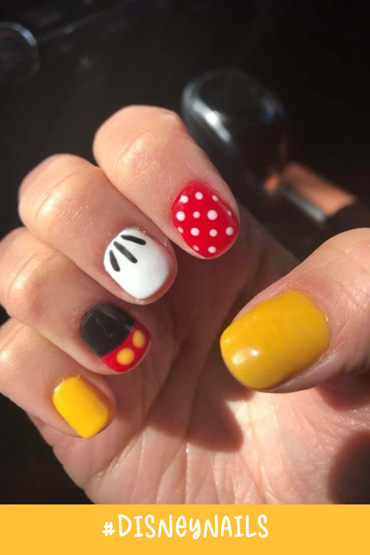 These Disney nails showcase bright colors and iconic details. Red polka dots, yellow nails, and a black and red Mickey pattern nail make this an easy yet eye-catching Minnie and Mickey-inspired nail art.