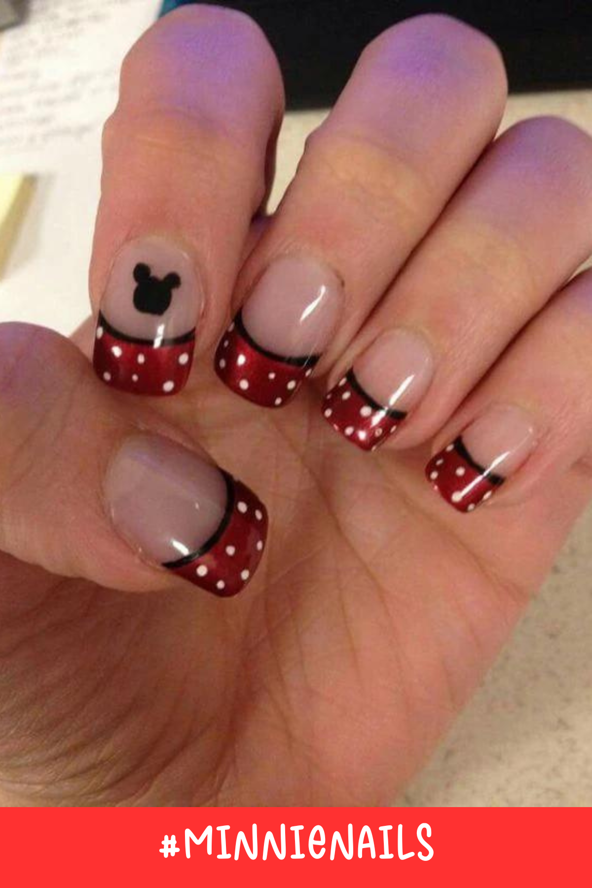 This Minnie nail design adds a bold red tip with white polka dots and a Mickey silhouette on a clear base. The black lining along the tip adds an elegant finish to these Disney-inspired nails.