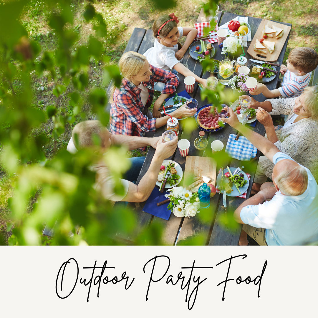 A photograph of people enjoying an outdoor party with lots of food