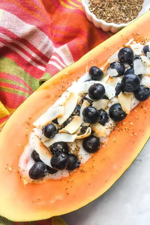 Start your day with a burst of tropical flavors! This Papaya Breakfast Bowl, filled with creamy coconut yogurt and fresh berries, served in a sliced mango, is not only insta-worthy but also gluten-free and vegan. Perfect for a healthy and delicious breakfast! ?? #HealthyEats #VeganBreakfast