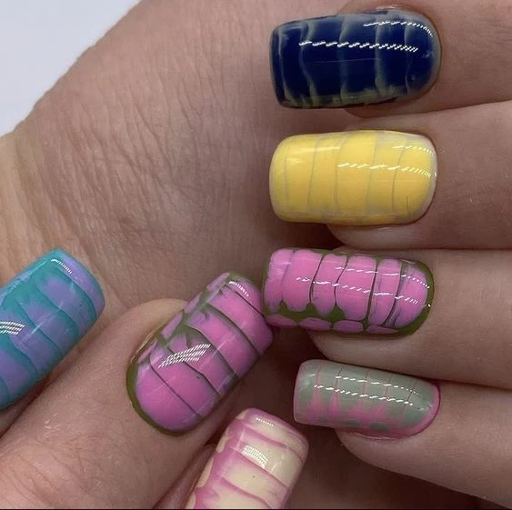 These nails feature a unique snake skin pattern with a pastel twist, showcasing a variety of soft shades like pink, blue, yellow, and green. Each nail has a glossy finish that enhances the intricate design, making it perfect for those who love a colorful and playful style.