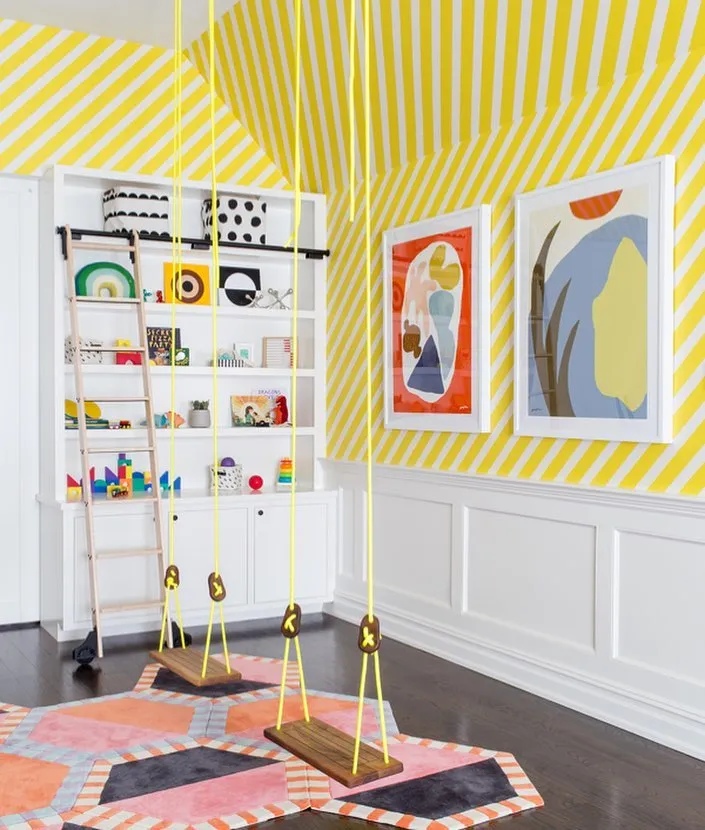 Modern Indoor Playground – With built-in swings, vibrant yellow stripes, and playful abstract art, this space blends fun and design for an unforgettable playroom.