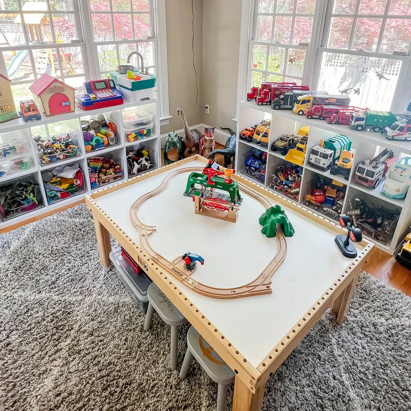 Toy Storage with Cubby Shelves & Train Table 🚂🔠This kid-friendly playroom setup includes low cubby shelves with clear bins for toy storage and a central play table for hands-on activities. The natural light and open layout make this space both practical and fun!