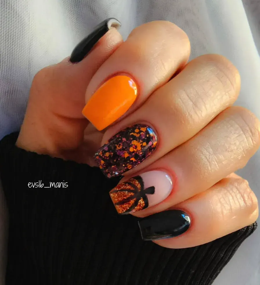 Black and orange nails get a glittery glow-up with sparkling pumpkin details. This design is Halloween-ready but cozy enough to wear into November too.