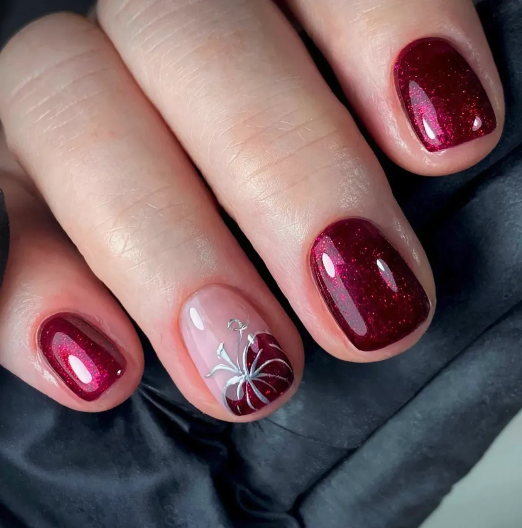Deep red nails get a chic seasonal upgrade with a single silver-lined pumpkin accent. This design feels classy and understated, perfect for fall weddings or Thanksgiving dinner.