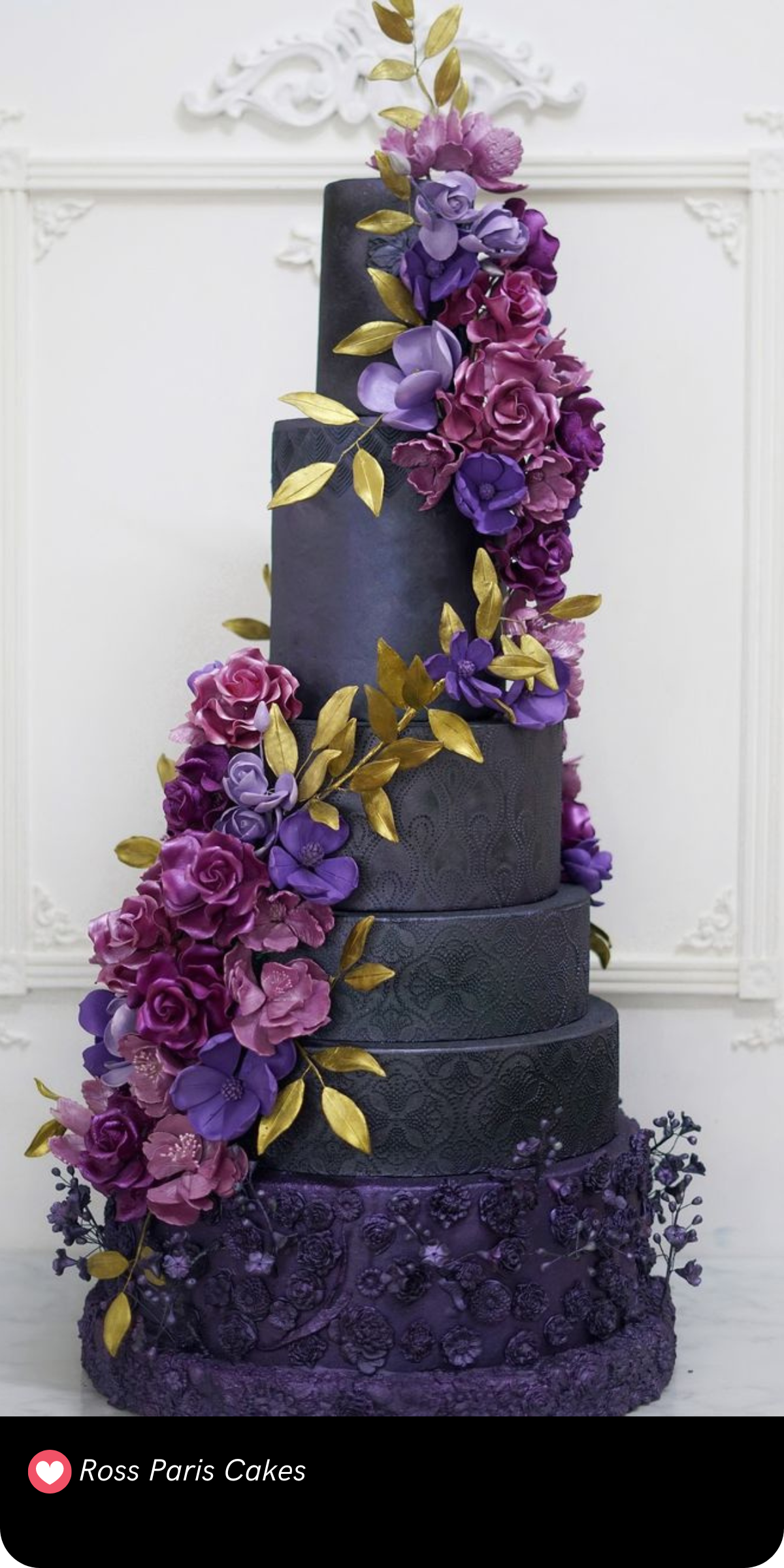 Talk about drama! This towering masterpiece is covered in textured floral details and wrapped in a cascade of deep violet and gold leaves—perfect for a luxurious, fairy-tale wedding.