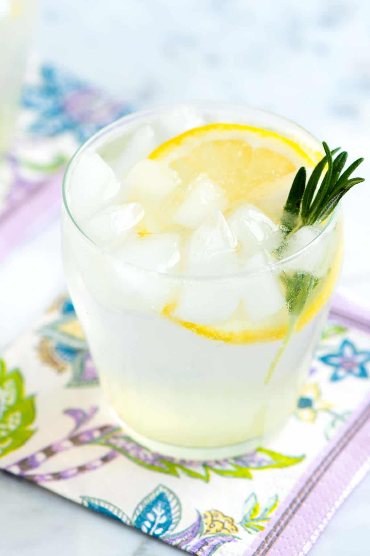 This elegant cocktail features gin, sparkling water, rosemary simple syrup, and fresh lemon juice. A light and refreshing option for your festive drinks.