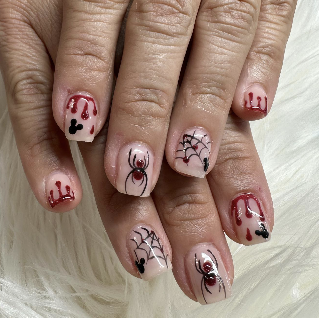 These nails bring all the creepy-crawly Halloween vibes with a playful twist! The design combines elements of spooky spiders, dripping blood, and a subtle nod to a certain famous mouse, making it both eerie and fun.