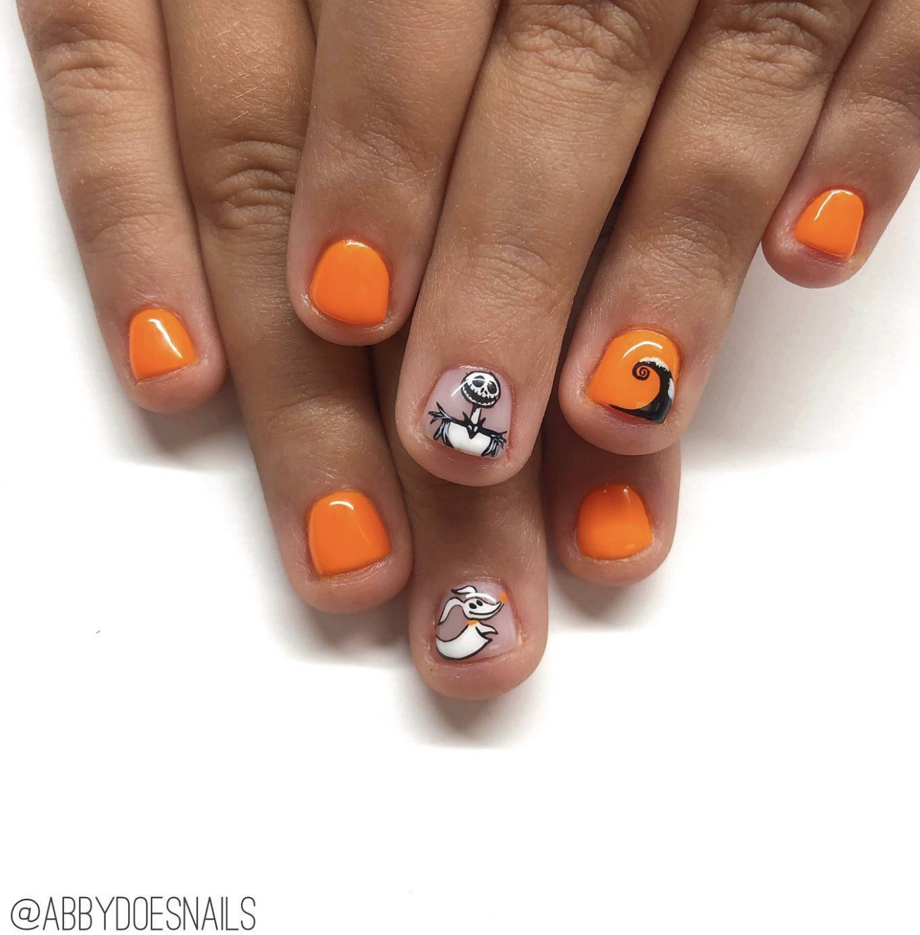 These nails are a delightful nod to The Nightmare Before Christmas, making them a perfect mix of spooky and cute for Halloween! The overall design keeps it simple yet super fun with a mix of bright orange nails and iconic character art.