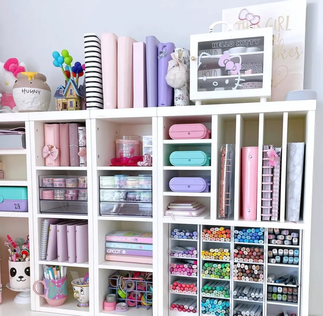 Color-coded pens, markers, and crafting tools stored in cubbies make this space a feast for the eyes. The upright storage for vinyl rolls is a great way to save desk space!