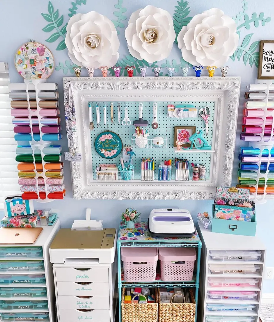 Framing the pegboard with ornate molding turns it into a functional yet decorative centerpiece. Bonus points for the pastel pink bins below, which combine style with hidden storage!