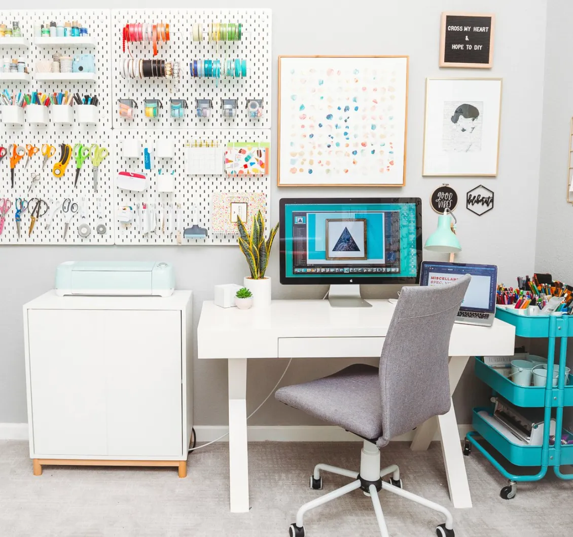 A pegboard wall steals the show in this craft space, offering dedicated hooks for scissors, washi tape, and even mini storage bins. Add in a rolling cart for mobile storage, and you’ve got an organization dream!