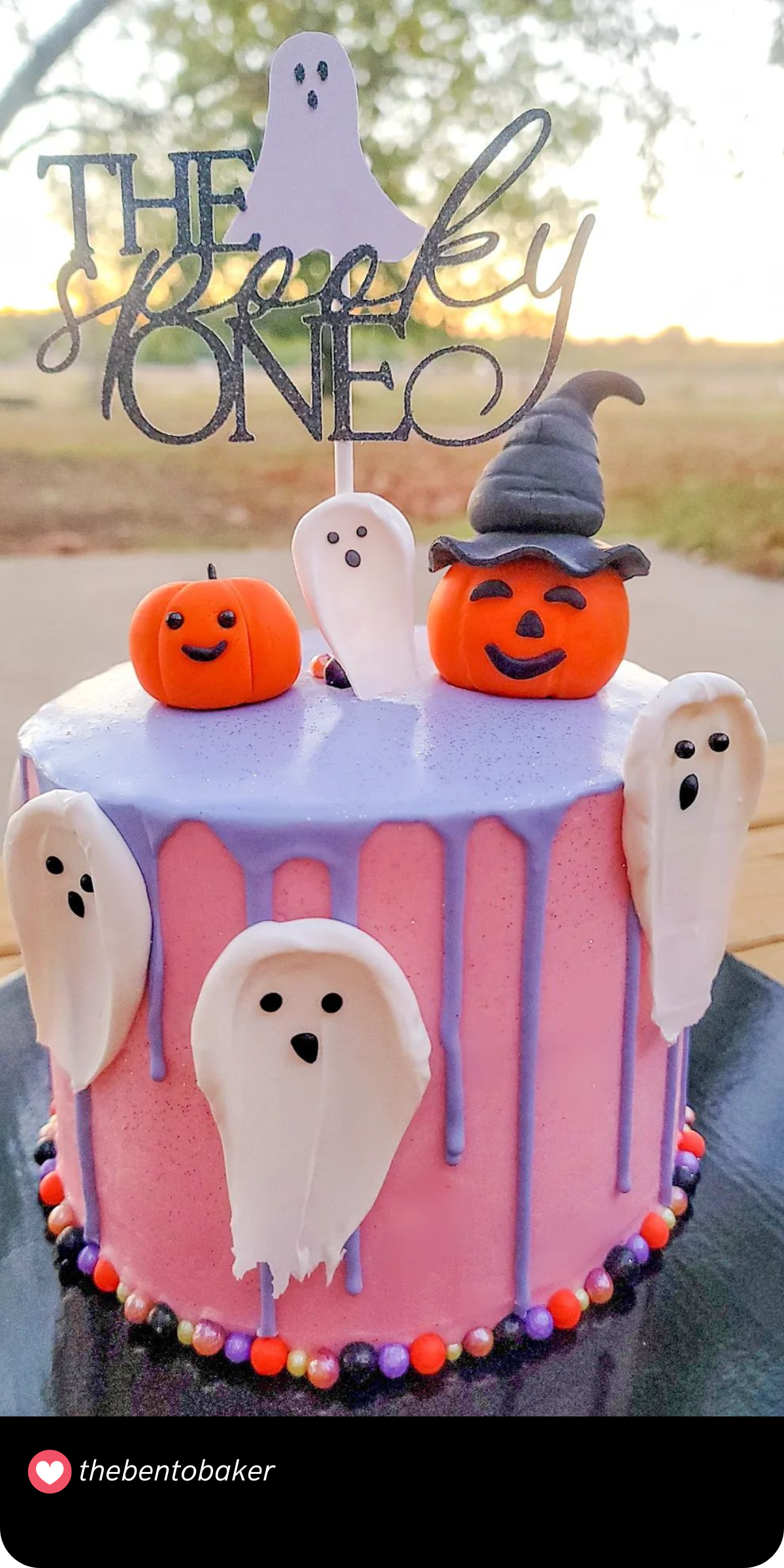 This delightful "Spooky One" smash cake features cheerful ghost decorations and playful pumpkins on a pink and purple drip cake. It’s a cute and festive way to celebrate a little one’s first Halloween birthday.