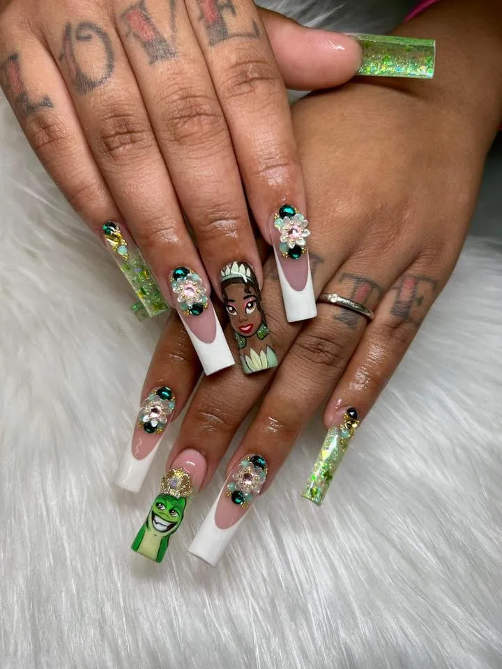 Fit for a queen of New Orleans! These Tiana-inspired nails shimmer with green and gold hues, elegant French tips, and 3D floral accents that capture her royal glow and love for nature.