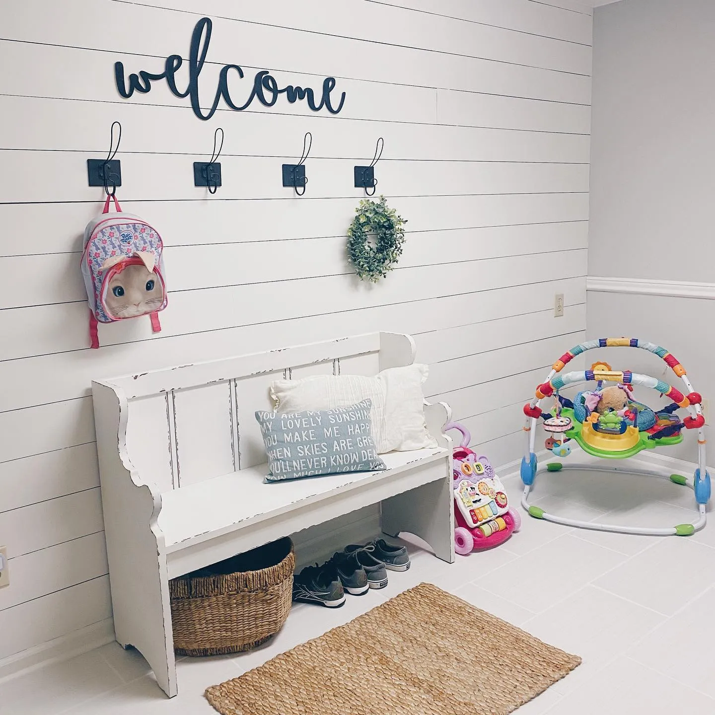 Entryway Play Space – A simple but effective use of a mudroom, featuring toy storage, a baby activity center, and hooks for easy-access toddler essentials.