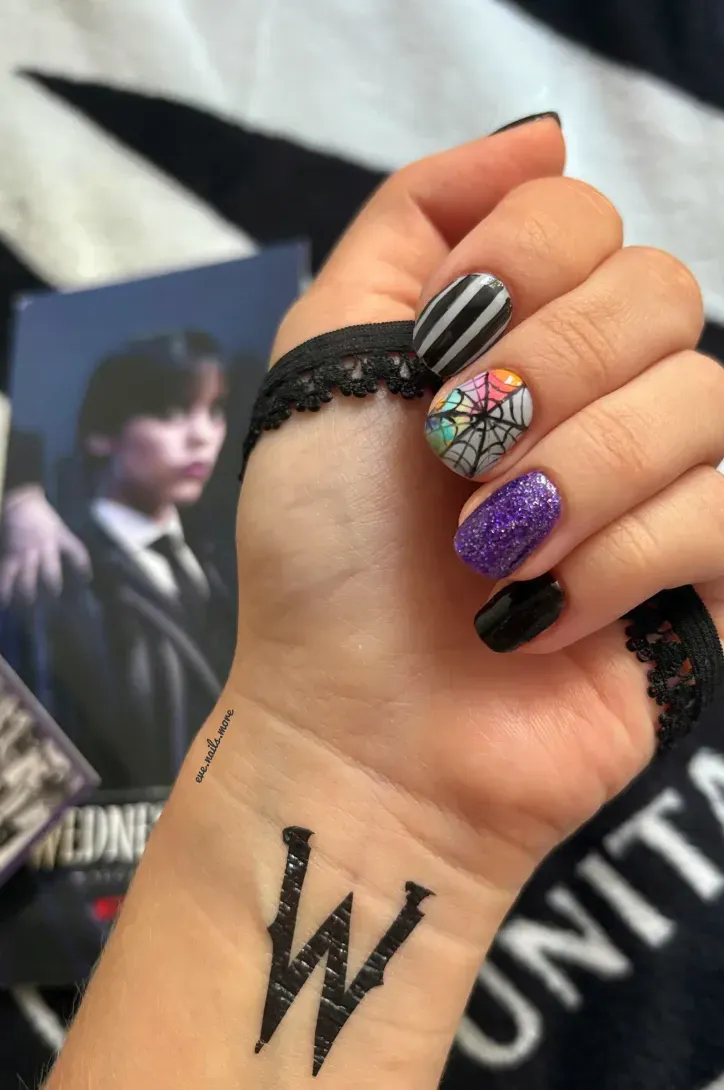Proving you don’t need long nails to channel your inner Addams, this short, rounded design blends stripes, webs, and collar-inspired shapes for a wearable Wednesday look.