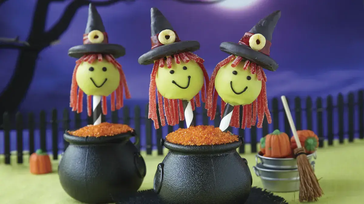 Witch Cake Pops – Topped with candy hats and red licorice hair, these cheerful witches are ready to brew up some sweet Halloween magic.