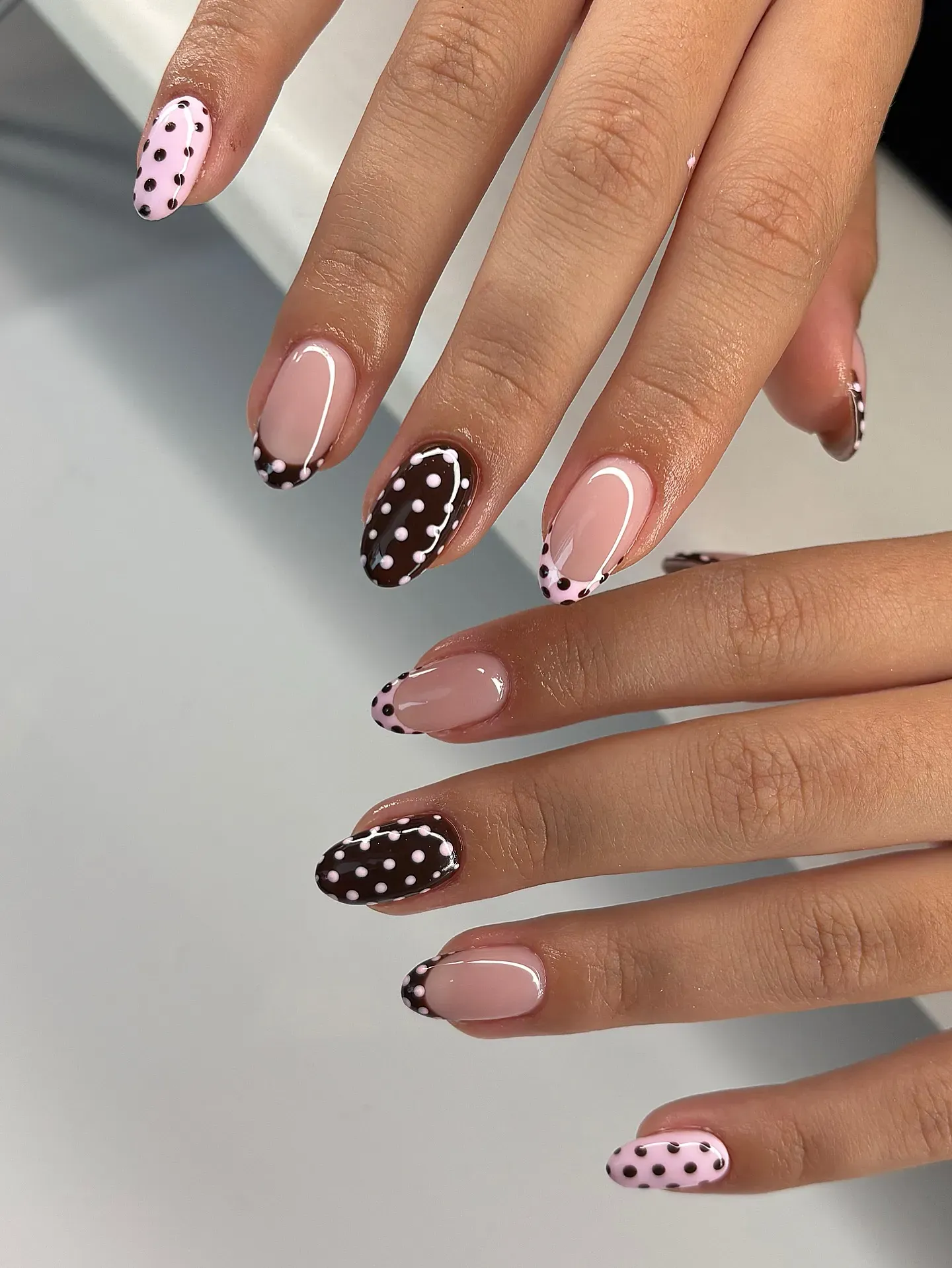 Chocolate brown meets soft pink with cute dotted French tips and accent nails — proof that simple details can make the biggest impact.