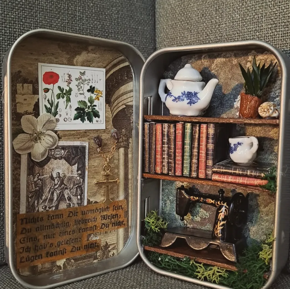  A beautifully detailed miniature room inside an Altoid tin, featuring a bookshelf, tea set, and tiny plants—an enchanting decor idea for dollhouse enthusiasts.