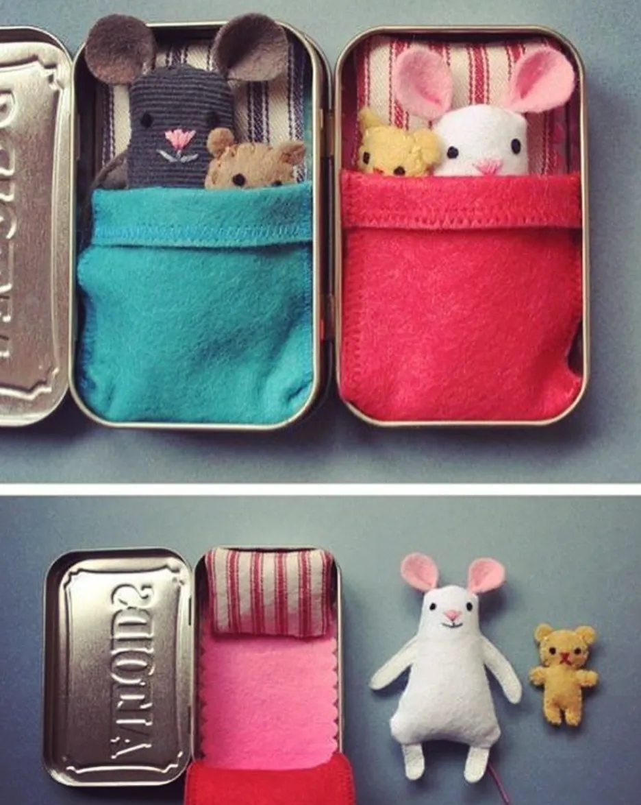 An adorable Altoid tin turned into a cozy mouse bed, complete with tiny blankets and pillows—a sweet idea for imaginative play or decoration.