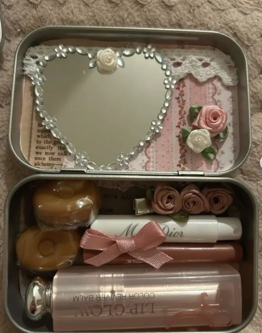 A chic and elegant DIY beauty kit inside an Altoid tin, featuring a heart-shaped mirror, pastel roses, and lip essentials for on-the-go glam.