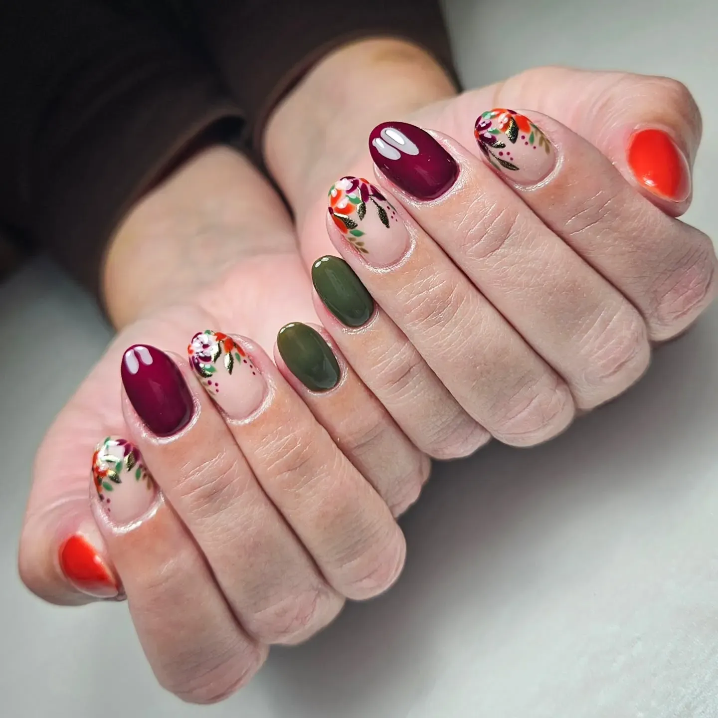 Burgundy, olive, and orange shades with delicate floral accents? Absolutely stunning. These nails blend deep fall nail colors with a soft botanical touch that feels fresh for 2025.