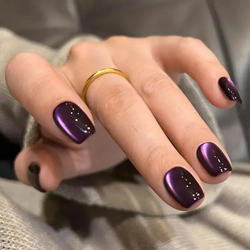 These trendy purple nails feature a magnetic cat-eye effect that reflects light beautifully. The moody plum shade adds a cozy yet luxurious twist for cooler months.