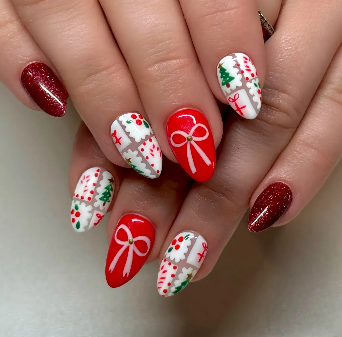 These cute Christmas nails feature a playful mix of red bows, Christmas trees, holly, and gift-wrap designs. Ideal for anyone who loves a cheerful holiday manicure that stands out! ๐โค๏ธ