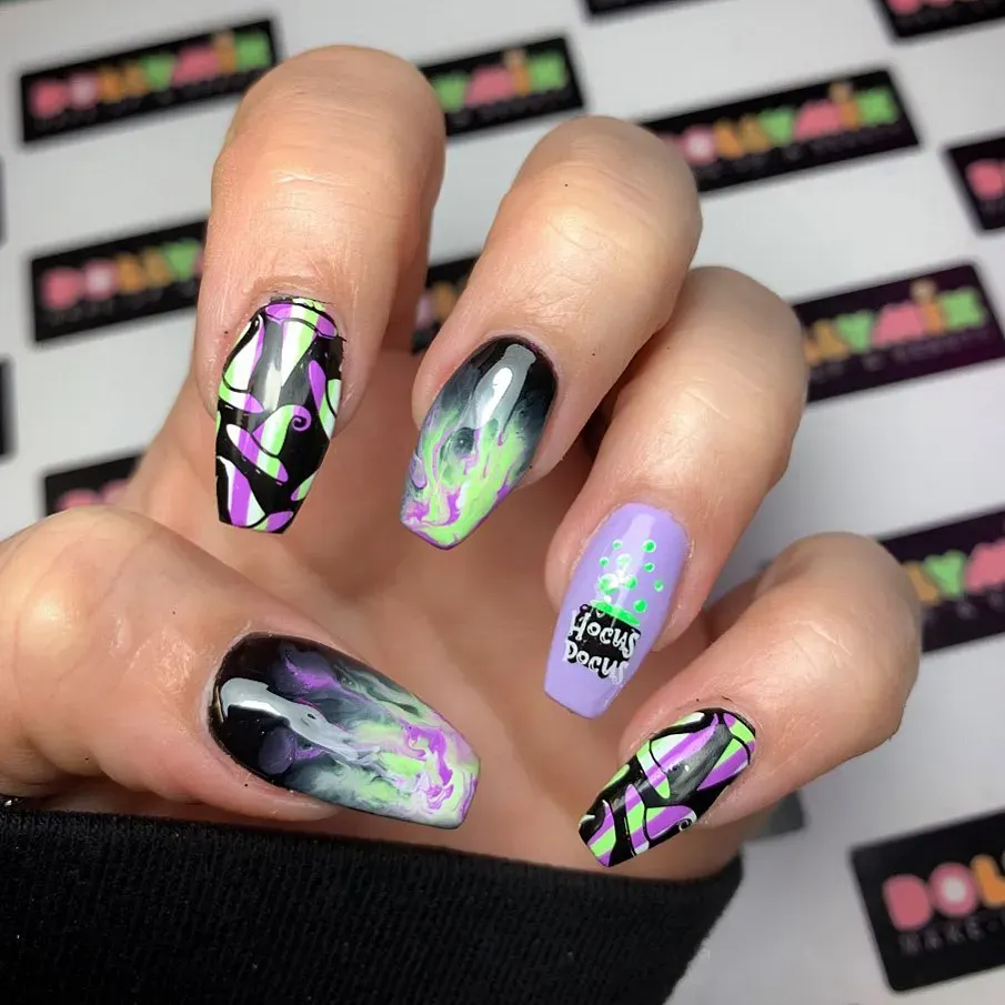 Swirling purple, green, and black give this mani serious Hocus Pocus energy — like a magical potion bubbling under a full moon. The lilac accent nail with neon dots and the “Hocus Pocus” lettering ties it all together for a spellbinding Halloween look.