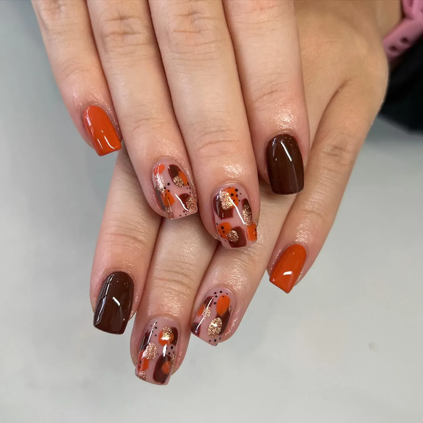 Brown, orange, and gold come together in this glossy mix of swirls and dots. It’s the perfect combination of trendy and timeless for your autumn nails 2025 mood board.