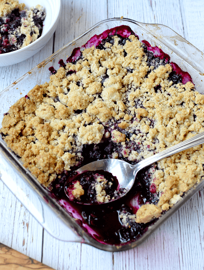 This delicious gluten free blueberry crisp is easy to make and eat! An oat crumb topping covers jammy blueberries for a dessert so delicious you'll make it over and over.