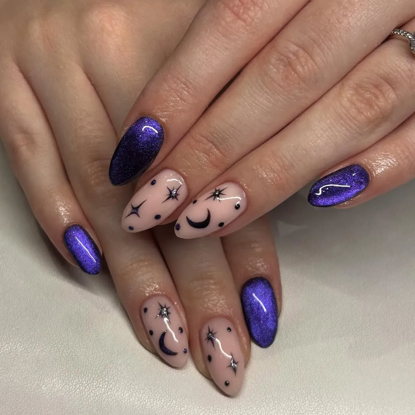 A cosmic dream come true โ this celestial nail art pairs deep purple galaxy glitter with delicate moon and star details. The perfect balance of fairytale nails and modern magic. ๐๐
