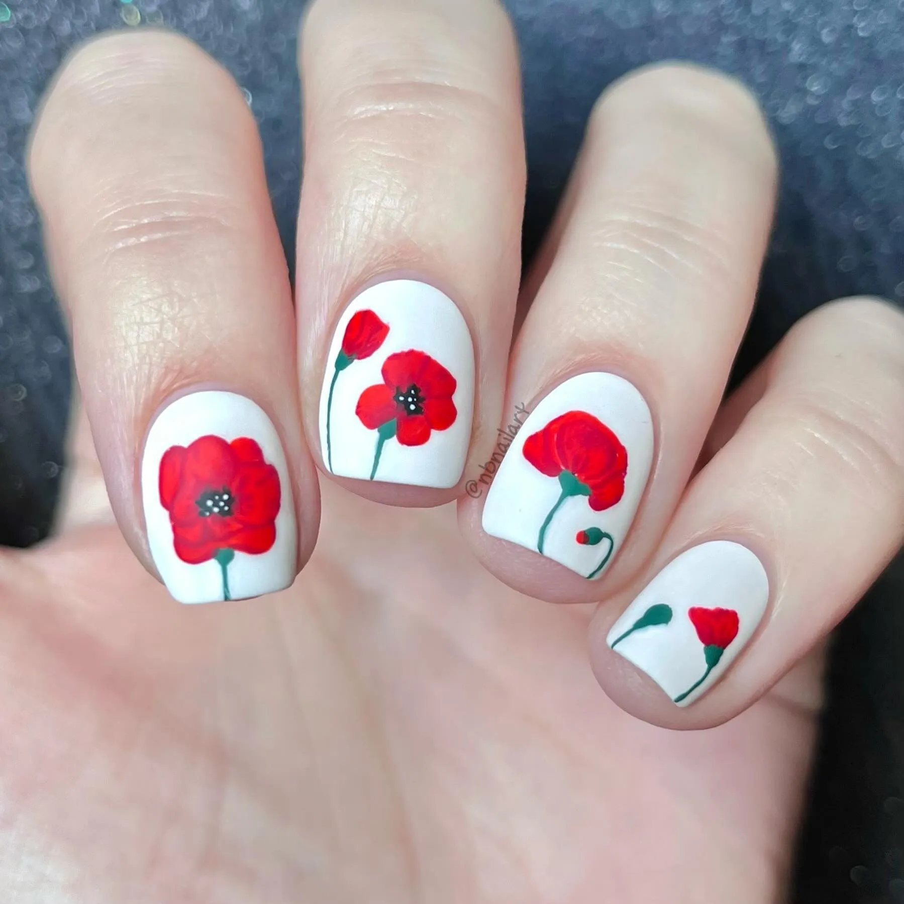 If you prefer a fresh, modern twist, this white poppy nail art from @nbnailart is for you. Clean white nails with hand-painted red blooms give a bold yet peaceful vibe — perfect for a November manicure that feels both stylish and symbolic.