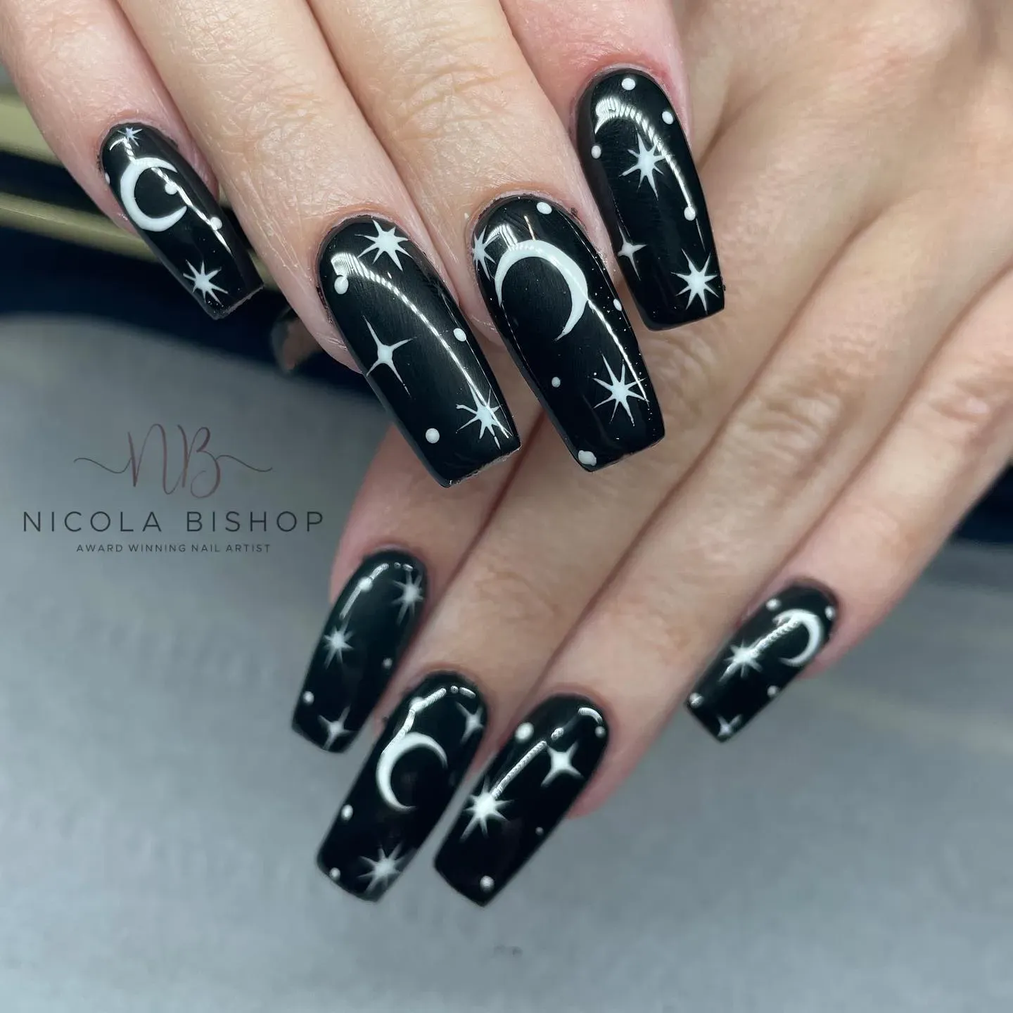 Black matte polish covered in delicate white crescent moons and twinkling stars โ elegant, sleek, and perfect for simple witchy nails that still make a statement. ๐โจ