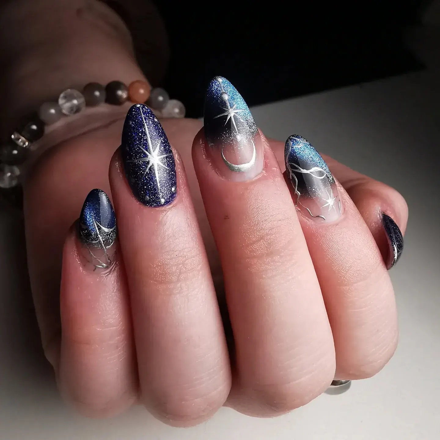 Midnight blue ombrรฉ nails with silver stars and moons bring serious celestial nail art energy โ like a wearable galaxy on your fingertips. ๐๐ซ