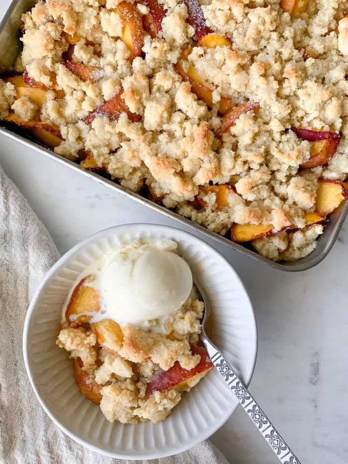 This peach cobbler might just be the best dessert in the world! I really think there’s nothing more satisfying than a peach cobbler made with fresh peaches and a big old scoop of homemade ice cream on top! Whether or not you agree, I think it goes without saying that you need to try this recipe.