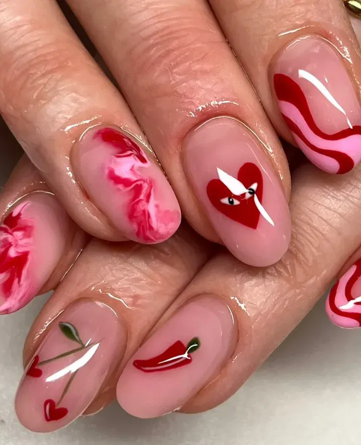 If you're searching for pink nail inspo for your Valentine's nails this design mixes marble with cherry hearts and a hot pepper!
