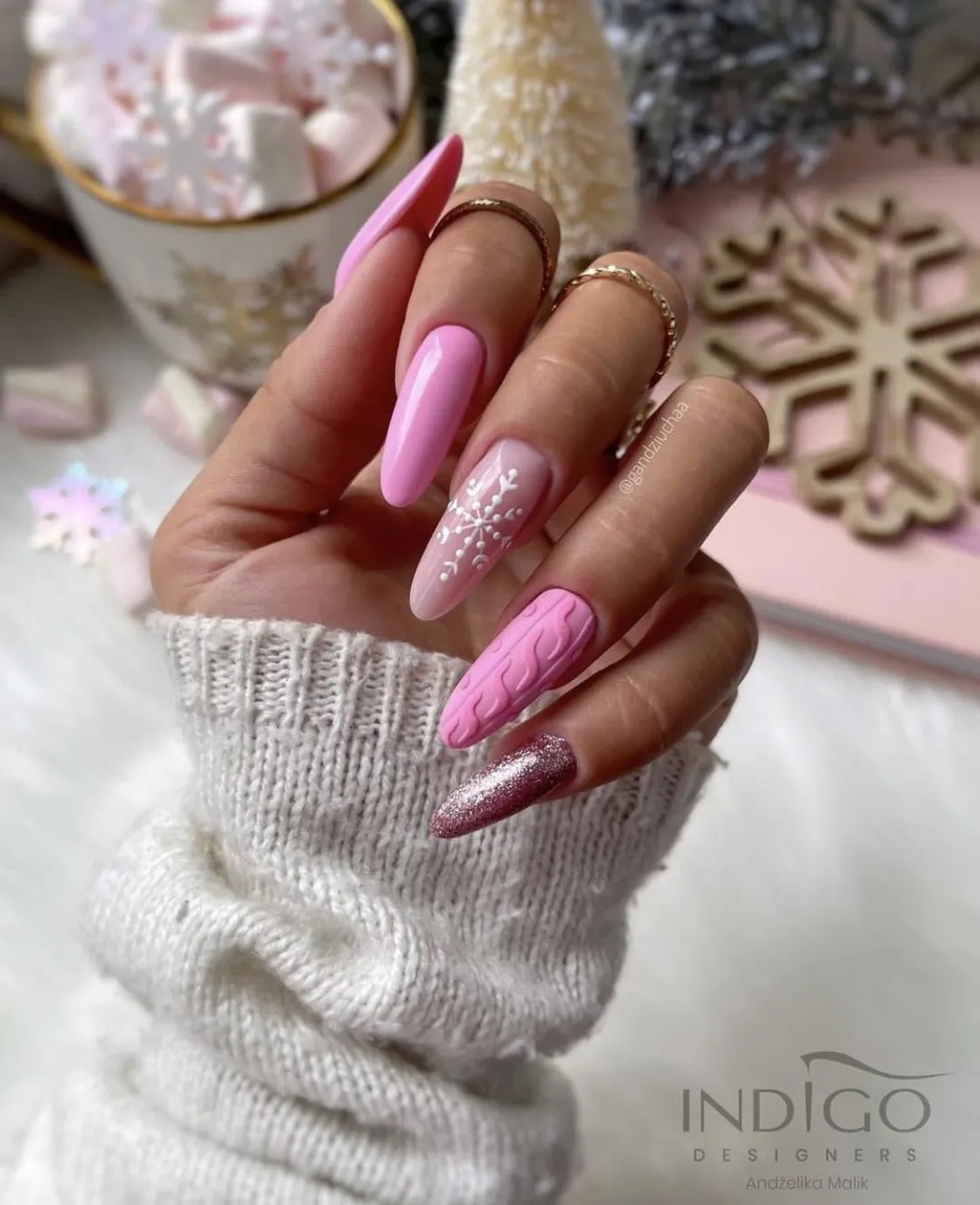These light pink winter nails are giving major “hot chocolate by the fire” energy. The mix of soft pink polish, glitter, and a detailed sweater print nail accent makes them classy yet totally wearable for everyday winter style.