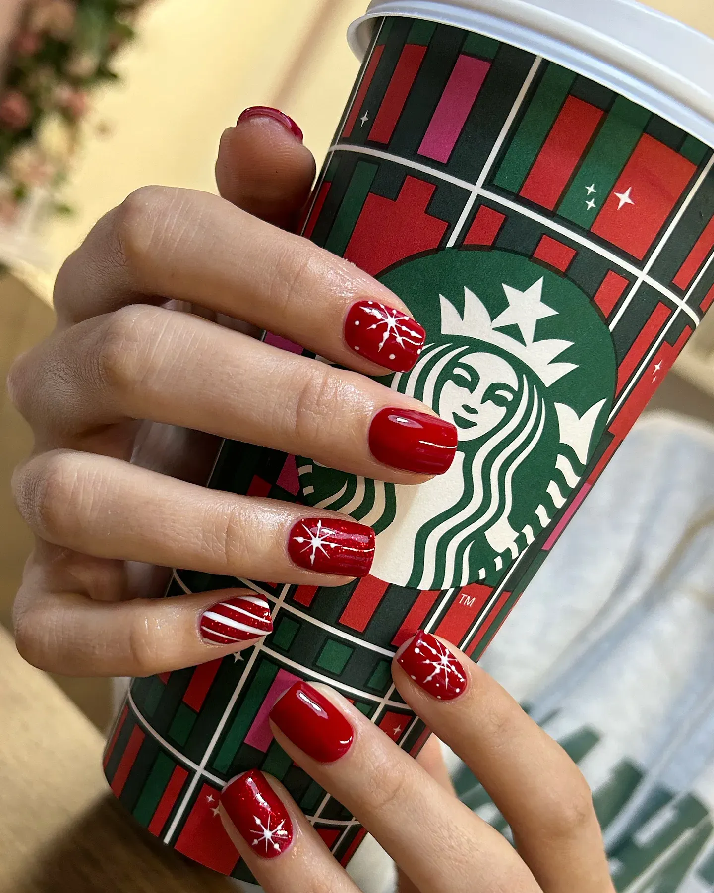 Simple red nails with white stripes and snowflakes โ a timeless December nail design that pairs perfectly with your favorite Starbucks cup and cozy knits. โ๐