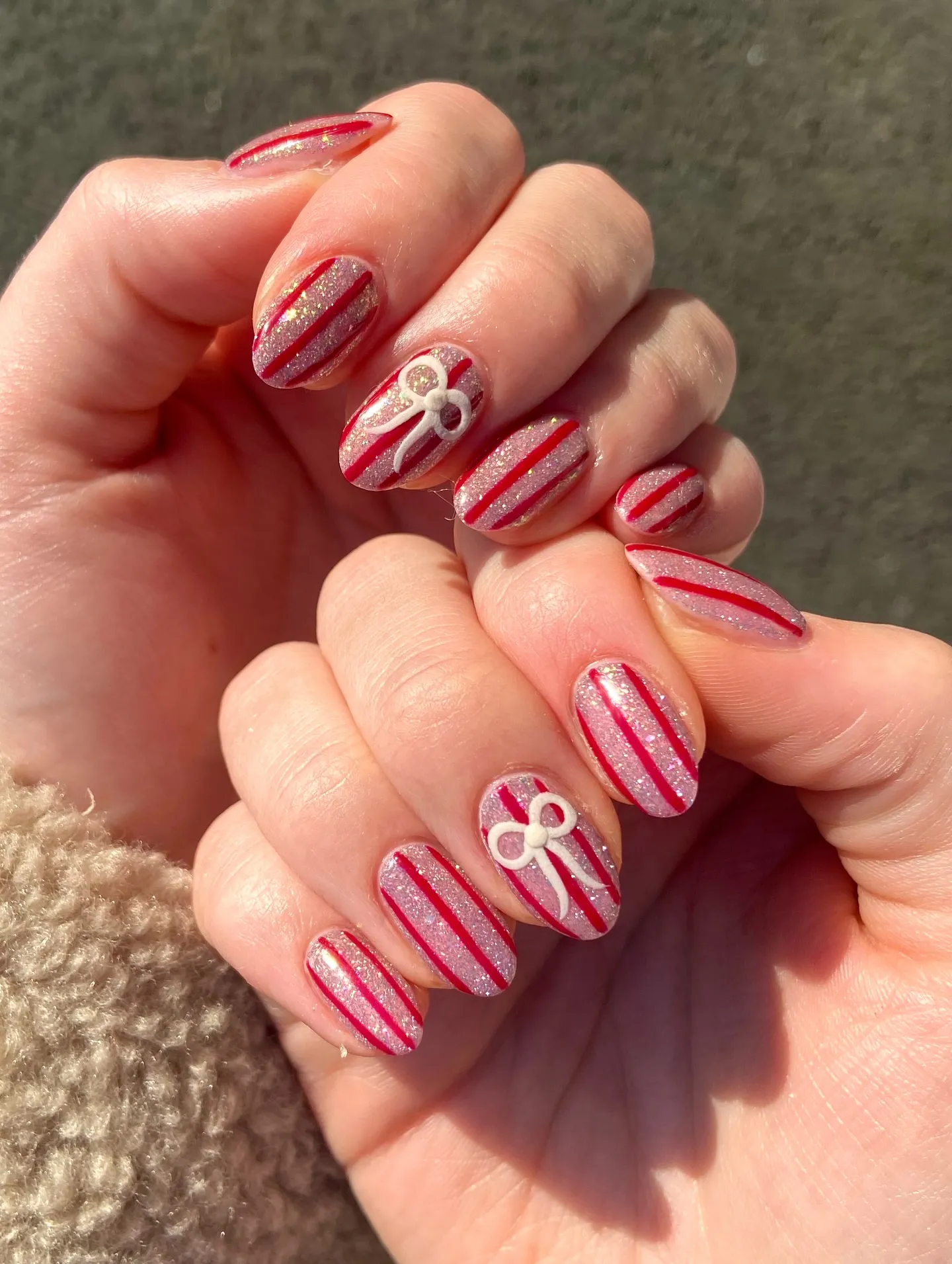These glittery striped nails from @sl_yournailgal are pure candy cane perfection. The fine shimmer base gives them that frosty glow, while the dainty white bows add a touch of cute elegance — a must-try idea for Holiday Nails Winter Christmas.