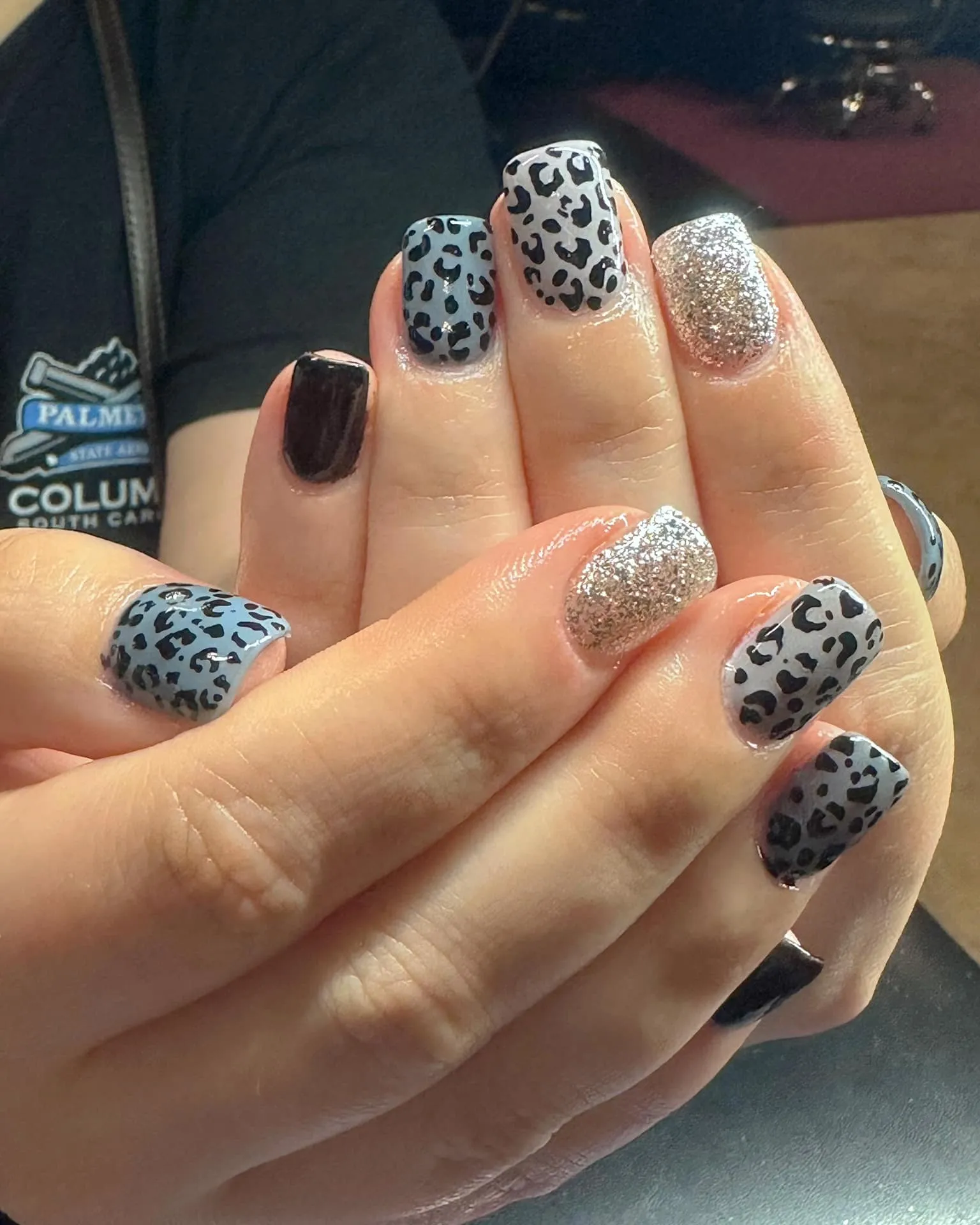 @slayruby13 went cool-toned and sparkly with a combo of matte blue leopard print, glossy black, and full glitter nails. The square shape gives the whole look a polished, modern finish.