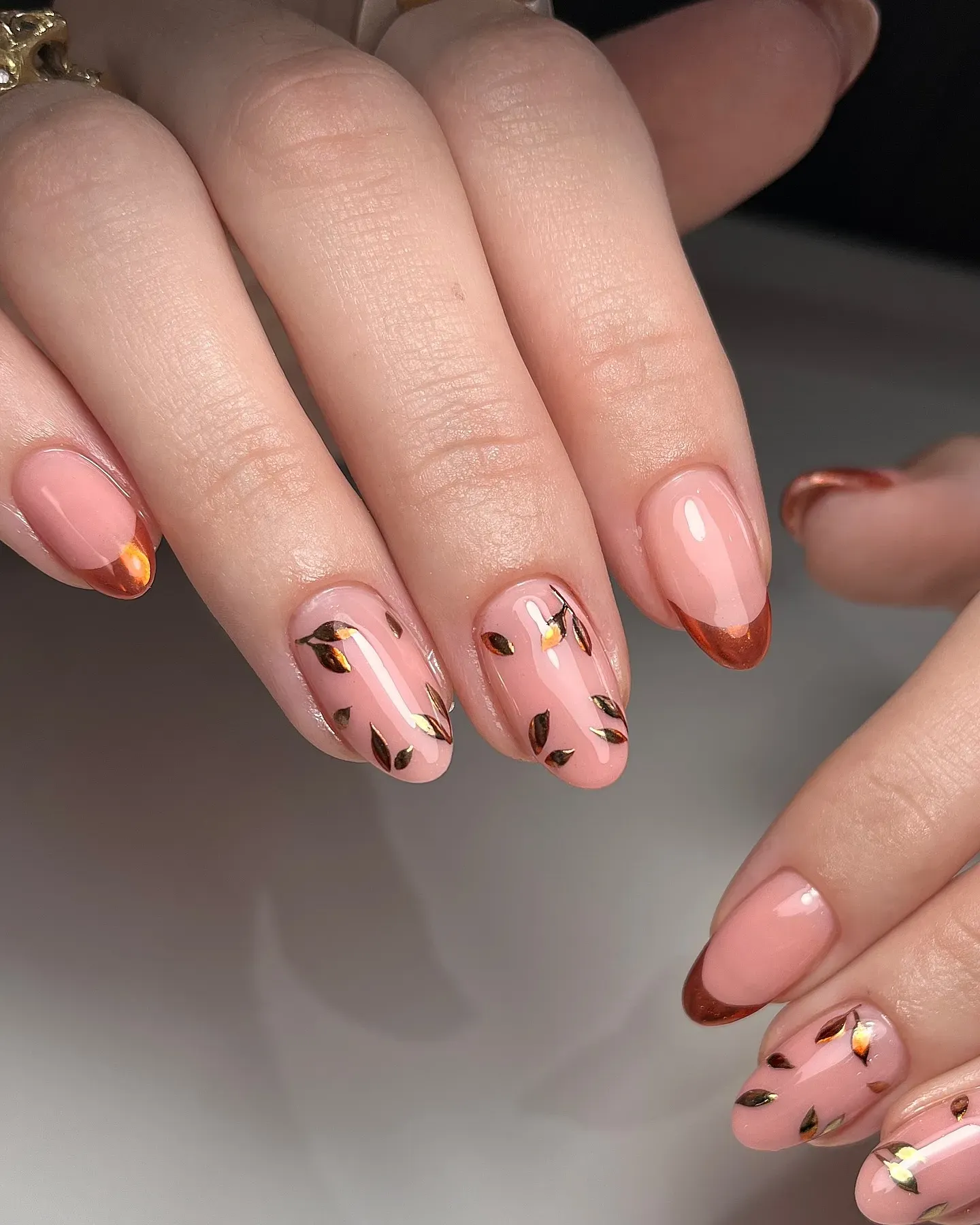 Soft peachy pink paired with shiny copper chrome tips and foil leaves for a polished fall-ready look.