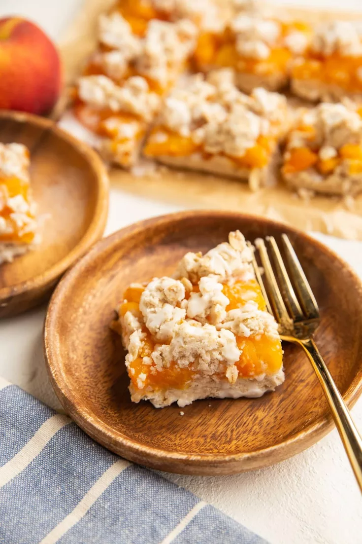 Gluten-Free Vegan Peach Pie Bars with oatmeal shortbread crust, crumble topping and a simple glaze is a perfectly sweet treat for summer entertaining! Made with only 6 ingredients, these easy to make bars are vegan with a refined sugar-free option.